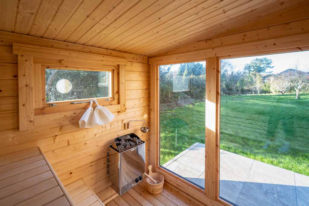 Bright hallway with wooden flooring, white walls, and a staircase leading upstairs. The space is illuminated by natural light, creating an open and welcoming entryway.
